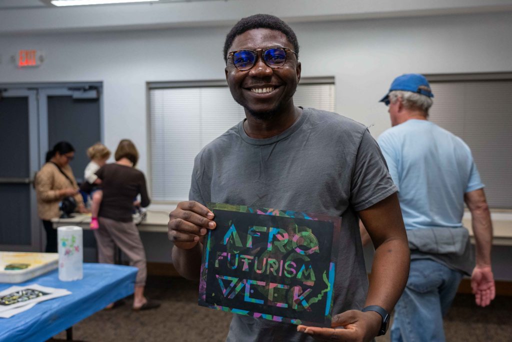 student posing with AFW screen print he made.
