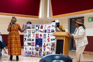 Seniors on the Move Community members display the Memory Quilt while Carla introduces them into a mic